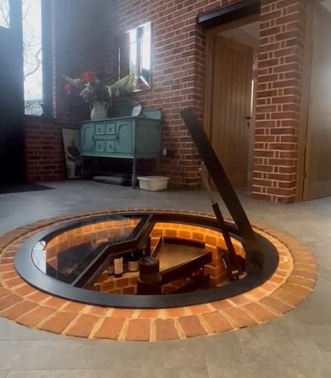 Electric wine cellar door over spiral cellar with glass lifting automatically